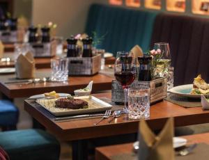 a table with plates of food and glasses of wine at Sunday Hotel Berlin City West in Berlin