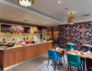 a restaurant with tables and chairs and a buffet at Sunday Hotel Berlin City West in Berlin +69 photos