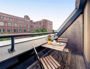 a balcony with a table and chairs on a building at Sunday Hotel Berlin City West in Berlin
