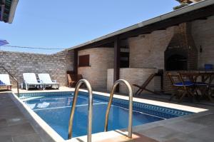 卡波布里奧的住宿－Pousada Casa do Telhado Verde，游泳池,带桌椅的庭院