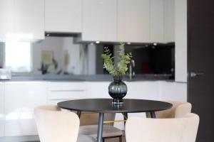 a vase with flowers on a table in a kitchen at Second Storey at Kew in Kew Bridge +16 photos