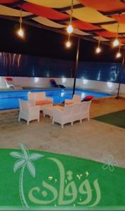 a room with couches and a table and a pool at Albaraka-farm in Az Zarqa