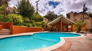 a swimming pool in front of a house at Best Western Woodland Hills in Woodland Hills