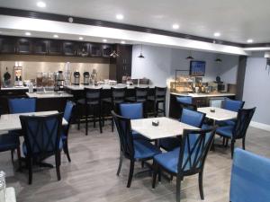 una sala da pranzo con tavoli, sedie e un bar di Best Western Plus Diamond Valley Inn a Hemet