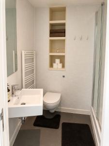 a white bathroom with a toilet and a sink at Cozy City View Apartment in Birmingham +6 photos