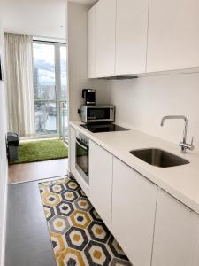 a kitchen with white cabinets and a sink and a window at Cozy City View Apartment in Birmingham