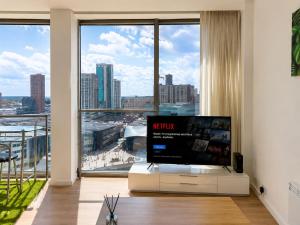 a living room with a tv and a large window at Cozy City View Apartment in Birmingham