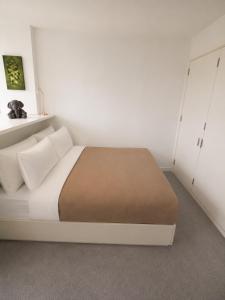 a bedroom with a white bed with a brown blanket at Cozy City View Apartment in Birmingham
