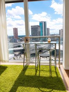 a glass table with a chair in front of a window at Cozy City View Apartment in Birmingham