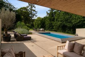 a backyard with a swimming pool and a patio at Exclusive Duplex Mansion with Sauna & Pool in Charlottenlund +95 photos
