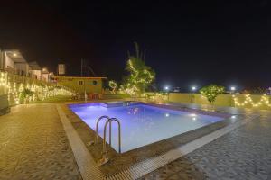 a swimming pool at night with lights on it at Prideinn Luxury Resort in Rishīkesh
