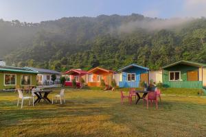 a group of houses with tables and chairs in a field at Prideinn Luxury Resort in Rishīkesh