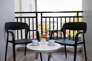 two black chairs and a table with cups on it at The BELL in Nai Yang Beach