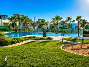 a resort with a swimming pool and palm trees at Rosarito Papas & ocean view Condo in Rosarito