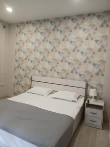 a bedroom with a large bed and a wall at Terra Hotel in Berezovka