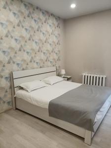 a bedroom with a bed and a stone wall at Terra Hotel in Berezovka