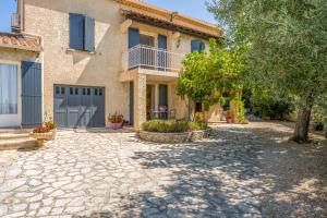 a house with a stone driveway in front of it at Chambres D'hôtes La Sousto in Châteaurenard