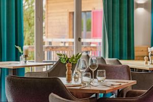 a restaurant with a table with wine glasses on it at Terra-Beka Lodge in La Chapelle-dʼAbondance