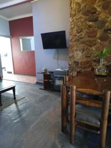 a living room with a table and a stone wall at Karee Laagte in Leeuwfontein