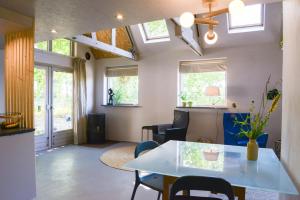 a living room with a table and chairs and windows at Atelier Markelo in Markelo
