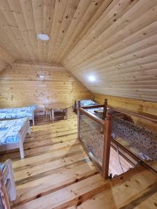 a room with two beds in a wooden cabin at Ранч ДИМ in Ivanjica