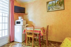 a kitchen with a table and a small refrigerator at Chambres D'hôtes La Sousto in Châteaurenard