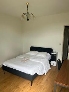 ein Schlafzimmer mit einem Bett mit weißen Laken und einem Tisch in der Unterkunft Basic Business Accommodation in Geel