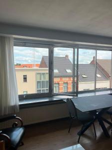 ein Zimmer mit großem Fenster, Tisch und Stühlen in der Unterkunft Basic Business Accommodation in Geel