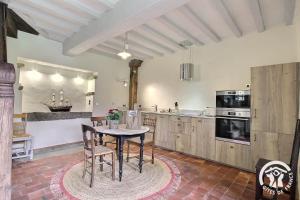 a kitchen with a table and chairs in a room at La tour carrée in Trimer