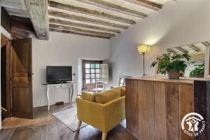 a living room with a couch and a television at La tour carrée in Trimer