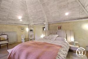 a bedroom with a large bed and a chair at La tour carrée in Trimer
