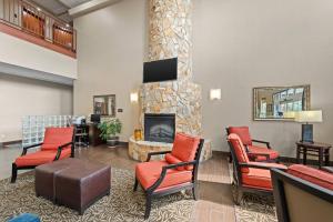 a lobby with red chairs and a fireplace at Comfort Suites Near Gettysburg Battlefield Visitor Center in Gettysburg