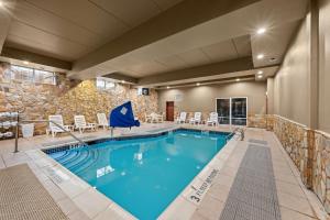 a pool in a hotel room with chairs and tables at Comfort Suites Near Gettysburg Battlefield Visitor Center in Gettysburg