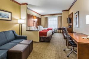 a hotel room with a bed and a couch at Comfort Suites Galveston Cruise Port Area - Beachside in Galveston