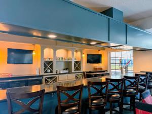 a large kitchen with a bar with wooden chairs at Comfort Suites Galveston Cruise Port Area - Beachside in Galveston