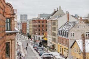a city street with parked cars and buildings at Nomad Hotel - Frederiksberg in Copenhagen