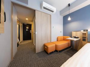 a room with a bed and a chair and a desk at Comfort Hotel ERA Sapporo North in Sapporo +39 photos