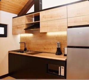 a kitchen with wooden cabinets and a refrigerator at LerHouseDilijan in Dilijan