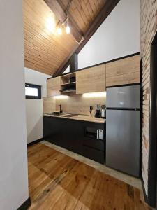 a kitchen with a stainless steel refrigerator and wooden floors at LerHouseDilijan in Dilijan +6 photos