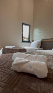 a bedroom with two beds with white towels on them at LerHouseDilijan in Dilijan