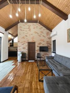 a living room with a couch and a brick wall at LerHouseDilijan in Dilijan