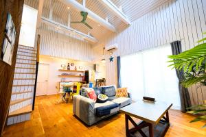 a living room with a couch and a table at Aoshima Surfers House in Miyazaki