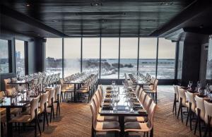 a dining room with tables and chairs and windows at Hyatt Regency Niagara Falls Fallsview in Niagara Falls