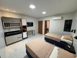 a hotel room with two beds and a tv at Loft Hage in Belém