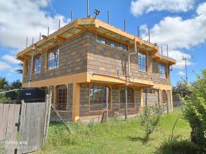 a house under construction on top of a field at WANDA's in Makandara