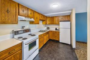 a kitchen with wooden cabinets and white appliances at Crestwood Hotel in Hinton
