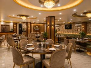 a restaurant with tables and chairs and a bar at Hotel Golden Crystal Best Hotel in kankarbagh Patna in Patna