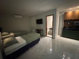 a bedroom with a bed and a kitchen and a television at Loft Hage in Belém +9 photos