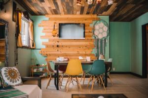 a living room with a table and a tv on a wall at Cottage ke'oke'o in Yomitan