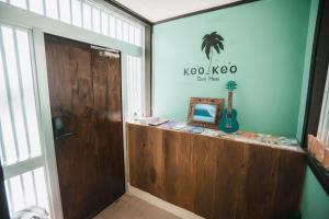 a room with a door and a guitar on the wall at Cottage ke'oke'o in Yomitan